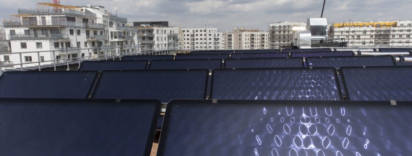 Ansicht von Solarzellen mit Hochhäusern im Hintergrund